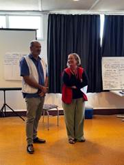 A person and person standing in a room

Description automatically generated