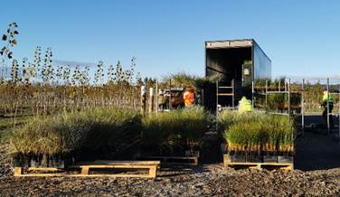 A container with a door open and a fenced area with plants

Description automatically generated with medium confidence