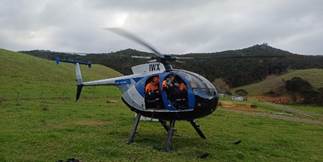 A helicopter on a grassy field

Description automatically generated