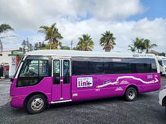 A purple bus parked on a road

Description automatically generated