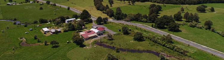 A green landscape with a road and buildings

Description automatically generated