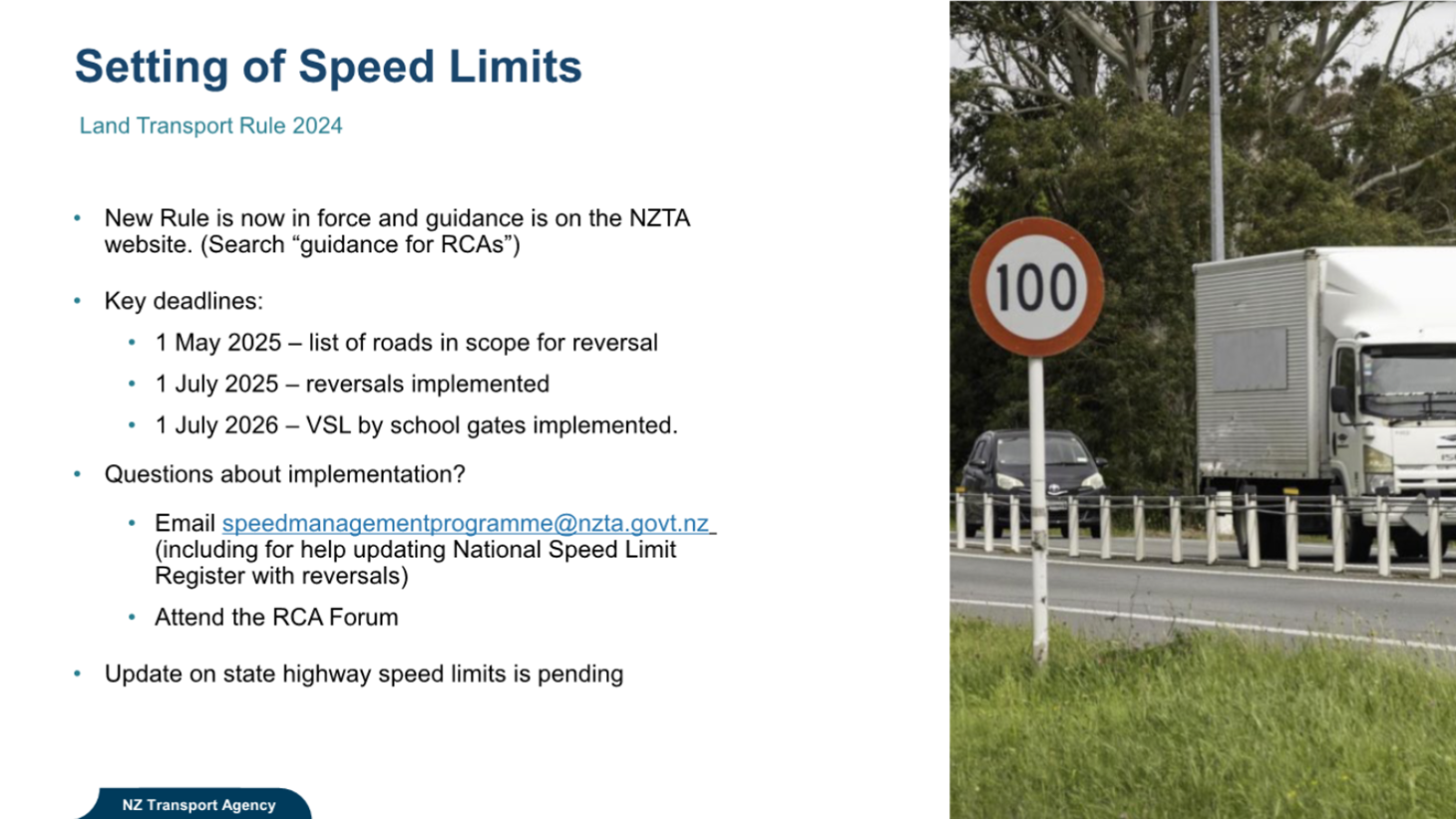 A speed limit sign next to a road

Description automatically generated