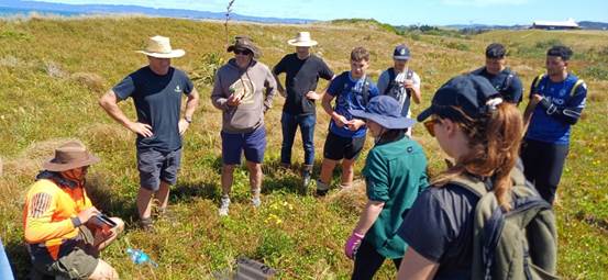 A group of people standing in a field

Description automatically generated