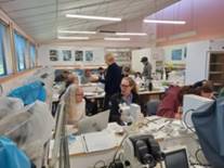 A group of people working in a room

Description automatically generated