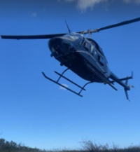 A helicopter flying over a field

AI-generated content may be incorrect.